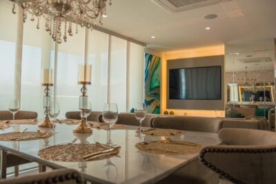 Elegant marble dining table and gold accents in a luxury coastal home, showcasing the sophisticated property inventory represented by Marie Howard-Griffin at Dana Blanks Real Estate.