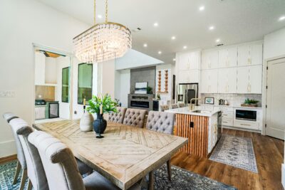 A cozy, modern living room with coastal decor and large windows, representing the Hampstead and coastal North Carolina lifestyle offered by Devon Denise Shepard.